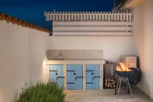 an outdoor kitchen with blue doors and a grill at Spacious holiday house in Istria in Peroj