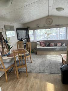 a living room with a table and chairs and a couch at Angie's caravan at Seawick in Saint Osyth