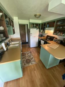 cocina con nevera blanca y suelo de madera en Hathaway a family home, en Corvallis