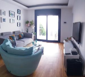 Apartamento MarySol B con Terraza y Piscina privada في بينالمادينا: غرفة معيشة مع أريكة وكرسي