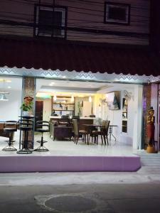 a dining room and living area of a house at night at Joy House Jomtien Beach in Jomtien Beach