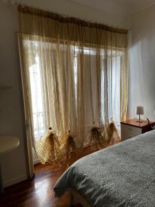 een slaapkamer met een bed en een raam met gordijnen bij N'amuri Guest House in Siracusa +35 foto's