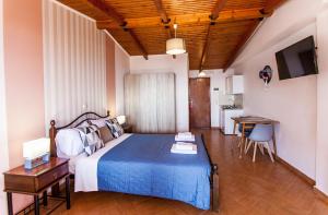 a bedroom with a bed and a table and a desk at Hotel Thetis in Tolo