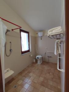 a bathroom with a toilet and a window at Agriturismo Su Solianu in Bari Sardo