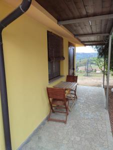 eine Terrasse mit 2 Stühlen und einem Holztisch in der Unterkunft Agriturismo Su Solianu in Bari Sardo