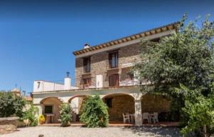 Casa de ladrillo grande con patio y árboles en Casa Joan de Fontsagrada, en Fontsagrada