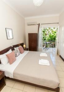 1 dormitorio con 1 cama grande y balcón en Hotel Thetis en Tolo