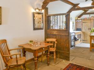 uma sala de jantar com uma mesa de madeira e cadeiras em The Workshop em Newton on the Moor