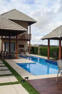 a house with a swimming pool with umbrellas at Illa Blue Village in Trairi