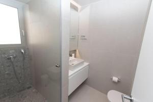 ein Bad mit einer Dusche, einem WC und einem Waschbecken in der Unterkunft Modern apartment close to Athens city center (Form_F2) in Athen