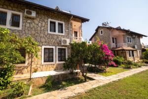 a stone house with a garden in front of it at Wonderful Home Close to Beach in Fethiye in Fethiye