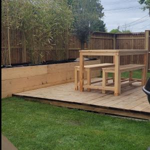 une terrasse en bois avec un banc et une clôture dans l'établissement La Cabane des salines proche mer, à Mesquer