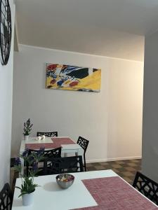 un comedor con mesa y sillas y una pintura en la pared en Antica Dimora Maravigna, en Catania