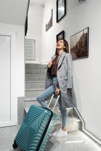 Una donna che sale le scale con una valigia di J&S Apartments a Niš