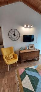 a living room with a couch and a clock on the wall at Ti Chôa - Casa da Praça in Angra do Heroísmo