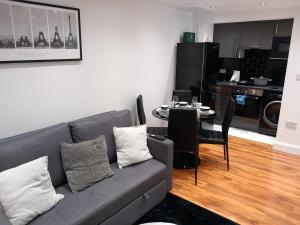a living room with a couch and a table at Heronsgate GH013 in Erith