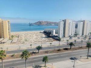 Blick auf einen Strand in einer Stadt mit Gebäuden in der Unterkunft Hermoso Departamento, playa La Herradura, Coquimbo in Coquimbo