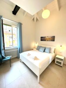 ein Schlafzimmer mit einem großen weißen Bett und einem Stuhl in der Unterkunft Isola in Rapallo