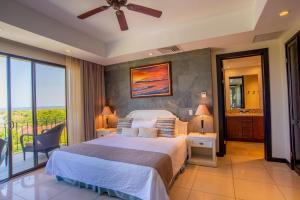 1 dormitorio con 1 cama grande y balcón en Carao T2-6 Luxury Penthouse Adults Only - Reserva Conchal, en Brasilito