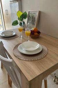 a table with two glasses of orange juice and a bowl of fruit at Lemon Tree Suite in Kos Town