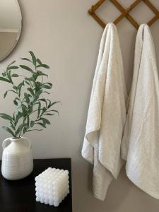 a bathroom with white towels and a table with a plant at Lemon Tree Suite in Kos Town