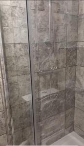a shower with a glass door in a bathroom at Heronsgate GH013 in Erith