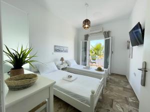 a living room with two beds and a tv at Odysseas Apartments in Marathokampos