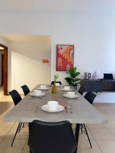 Grays Hostel By Haly في دبي: طاولة طعام عليها كراسي وأطباق