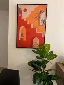 a plant in a room with a picture on the wall at Grays Hostel By Haly in Dubai