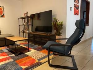 un salon avec une chaise et une télévision dans l'établissement Grays Hostel By Haly, à Dubaï