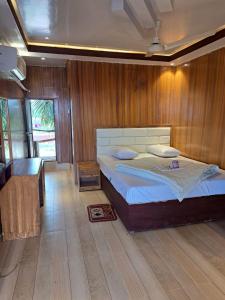 a bedroom with a bed and a wooden wall at Sandy Beach Resort & Restaurant in Cox's Bazar