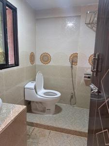 a bathroom with a toilet and a shower at Sandy Beach Resort & Restaurant in Cox's Bazar