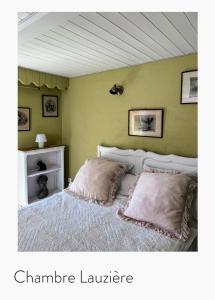a bedroom with a bed with two pillows at La Table d'Elodie in Le Béage