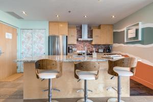 a kitchen with a island with bar stools at Les Immeubles Charlevoix - Le 760412 in Quebec City