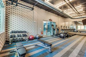 a gym with treadmills and exercise equipment in a room at Aloft Dallas Arlington Entertainment District in Arlington