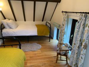 a bedroom with a bed and a chair in a room at St Milburga Chapel in Stoke Saint Milborough