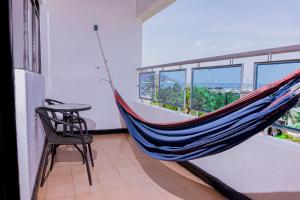 - un hamac dans une chambre avec une table et une chaise dans l'établissement Hotel Sol Inn Santa Marta, à Santa Marta