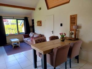 sala de estar con mesa de madera y sillas en Klein Horst - vrijstaande bungalow - Ermelo, en Ermelo