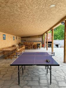 a ping pong table in a room with tables and chairs at White House in Yeghegnadzor
