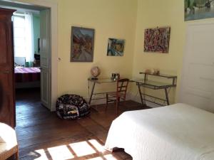 1 Schlafzimmer mit einem Bett sowie 2 Tischen und Stühlen in der Unterkunft La Suite du Peintre in Oloron-Sainte-Marie