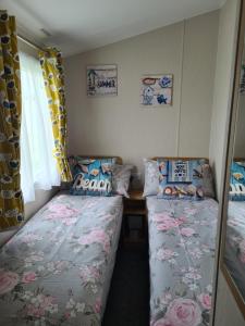 a bedroom with two beds and a window at Private Caravan Camber Sands in Camber