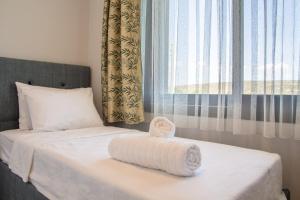 a bed with a towel on it with a window at Amazing Villa with Private Pool in Alacati Cesme in Alacati
