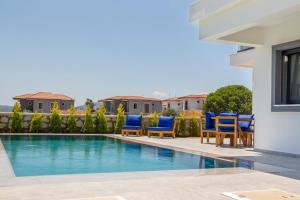 a villa with a swimming pool and blue chairs at Amazing Villa with Private Pool in Alacati Cesme in Alacati