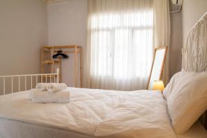 - une chambre avec un lit blanc et des serviettes dans l'établissement Authentic House, à Izmir