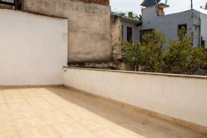 an empty balcony with a white wall and plants at Authentic House in Izmir