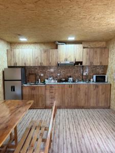 a kitchen with wooden cabinets and a wooden table at White House in Yeghegnadzor