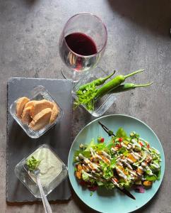 Langaland Glamping في Susenii Bîrgăului: طاولة مع طبق من الطعام وكأس من النبيذ