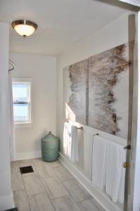 een badkamer met witte handdoeken en een schilderij aan de muur bij Cozy 2 BDRM Vacation Rental - 1 Mile to Dtwn Rapid City in Rapid City