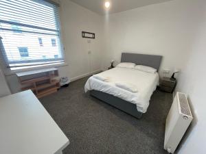 a bedroom with a white bed and a window at Seaside Hotel in Brighton & Hove