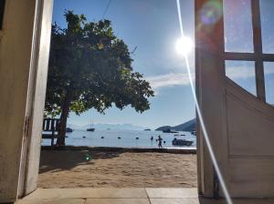 una puerta que da a una playa con vistas al agua en Pousada Mar Azul, en Abraão